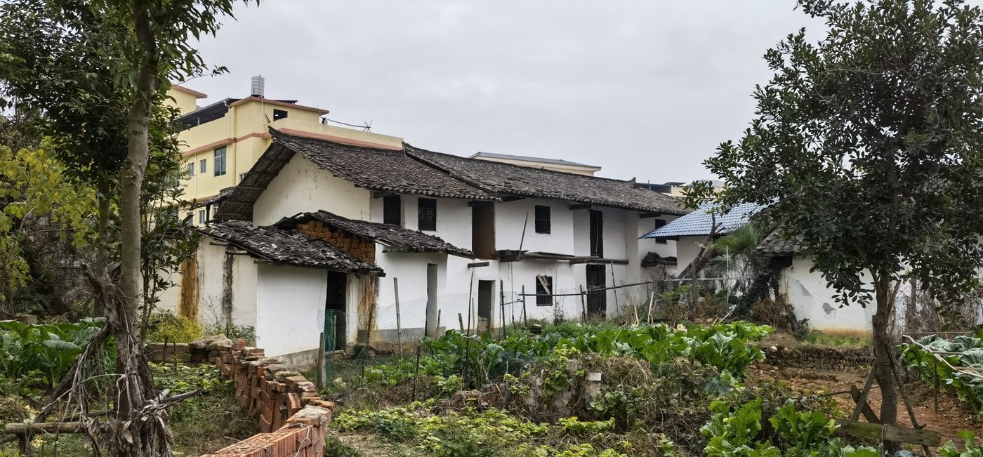 The old family house in the village, now surrounded by newer buildings